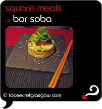 Top Secret Quote Bubble in black, with photo of bar soba asian fusion meal on square slate plate resting on black slatted mat on deep red table with chopsticks.  Caption: 'square meals'